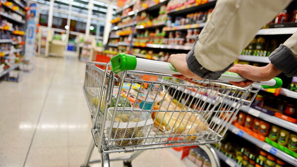 A Shopper Pushes a Trolley along a Supermarket Aisle