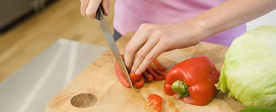 Woman chopping chili pepper with knife
