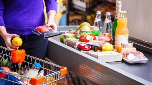 Young woman putting goods on counter stock