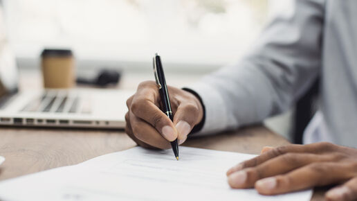 hands signing a document